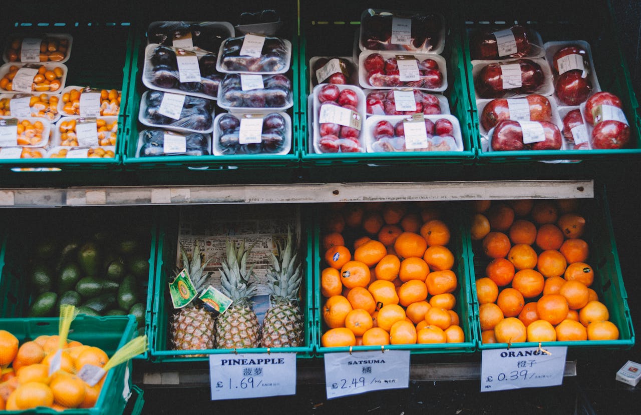 Colorful assortment of fresh fruits displayed in a local market stall with price tags.